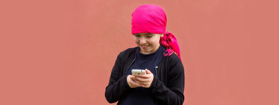 Girl With Cancer And Head Scarf Using Mobile Phone