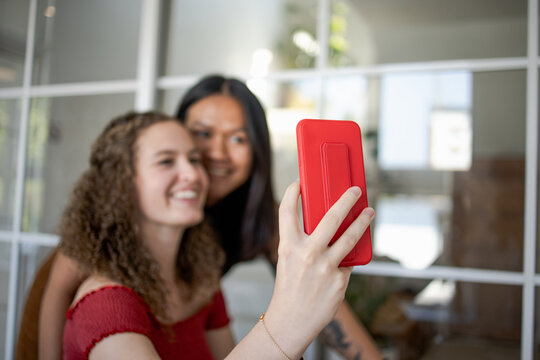 Pretty multiracial female friends taking selfie with smartphone Lifestyle selfie portrait of two young positive woman taking self photo