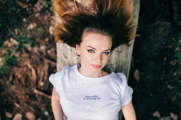 Portrait of young beautiful girl lying on the tree