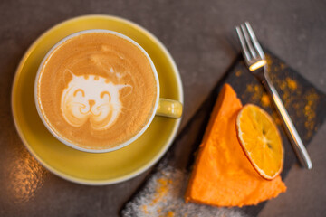 Coffee latte with orange cheese cake in cafe. Food, breakfast concept
