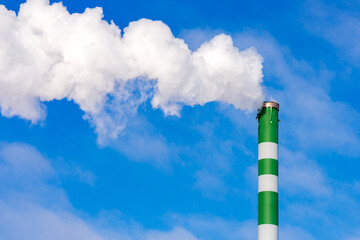One Industrial smoke pipe from chimney on blue cloudy sky.