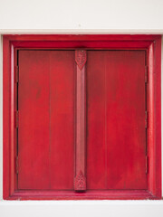 The closed double window shutters painted with red. Asian temple window texture