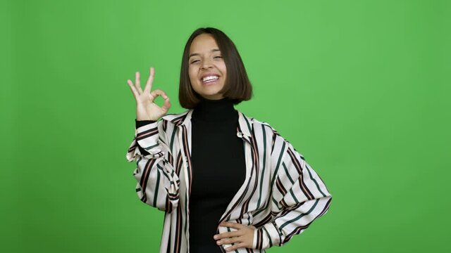 Woman showing ok sign with fingers over isolated background