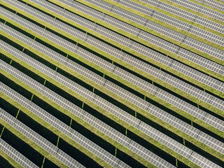 Aerial view of solar panels on green lawn field. drone shot, bird's eye