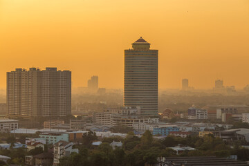 Obraz premium The blurred abstract background of the morning sun exposure to the tiny dust particles that surround the tall buildings in the capital, the long-term health issue of pollution