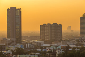 The blurred abstract background of the morning sun exposure to the tiny dust particles that surround the tall buildings in the capital, the long-term health issue of pollution
