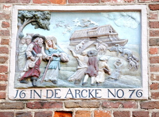 Old stone tablet of Noah's Ark, a carved and colorfully painted stone tablet on a brick wall in the old center of Amsterdam, serving both to identify and embellish the building