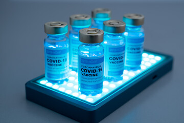 ampoules or vials with Covid-19 vaccine on a laboratory bench. SARS-CoV-2 Vaccination, immunization, treatment to cure Covid 19 Corona Virus infection. Medical concept.