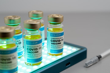 ampoules or vials with Covid-19 vaccine on a laboratory bench. SARS-CoV-2 Vaccination, immunization, treatment to cure Covid 19 Corona Virus infection. Medical concept.