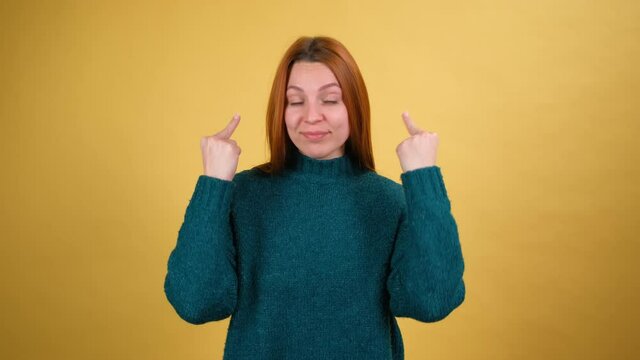 Back off. Disgruntled young woman showing middle finger to camera, expressing disrespect and negativity to haters, gesture of protest. Isolated on yellow background