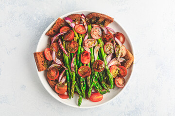 Warm green asparagus salad with tomato, onion and roaster bread