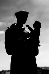 silhouette of a priest and baby