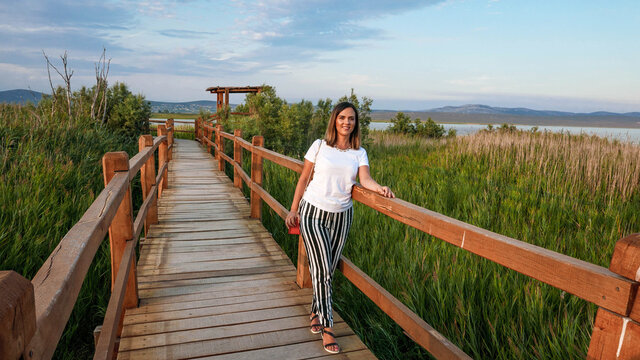 Front view of woman on wooden path in nature park. Lake Vrana, Croatia