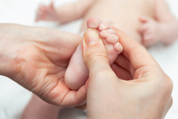 Masseur massaging little baby's foot. Hands of therapist rubs the small leg of infant. Health care concept for child and relax.