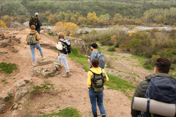 Fototapeta na wymiar Group of hikers with backpacks climbing up mountains