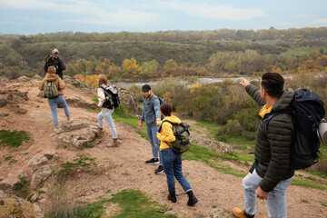 Group of hikers with backpacks climbing up mountains