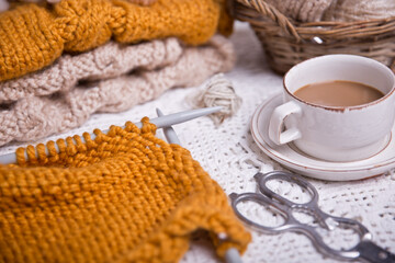 Obraz na płótnie Canvas A piece of knitting with ball of yarn and a knitting needles. Knitting project in progress.