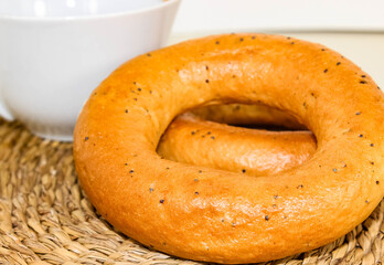 Bagels with poppy seeds with a white mug in the background.