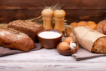 Obraz na płótnie Canvas Collection of grain bread and baked goods on wooden background. Various bread rolls. Healthy bread assortment. Shopping food supermarket concept. Bread made from wheat and rye flour. Bakery products