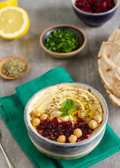A classic oriental appetizer dish - chickpea hummus with beetroot salad, olive oil and parsley
