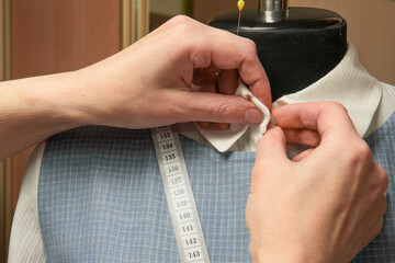 Obraz premium sewing workshop.women's hands gently make the last changes to the finished product.