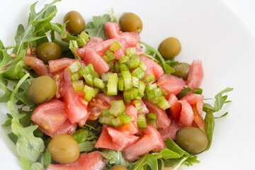Arugula salad with tomato olives and pickles