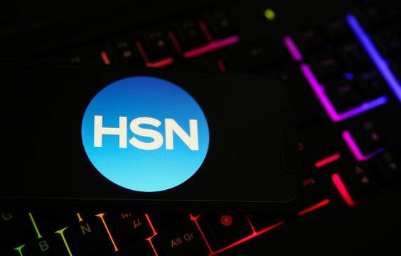 Viersen, Germany - February 9. 2021: Closeup of smartphone screen with logo lettering of HSN home shopping network on blurred computer keyboard
