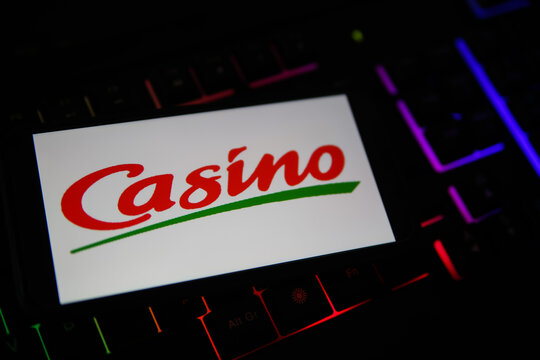 Viersen, Germany - February 9. 2021: Closeup of smartphone screen with logo lettering of geant casino on blurred computer keyboard
