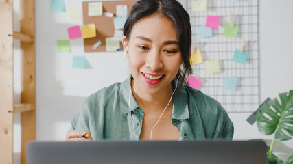 Asia businesswoman using laptop talk to colleagues about plan in video call while smart working...