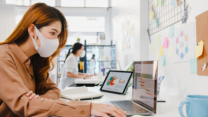 Asia businesswoman entrepreneur wearing medical face mask for social distancing in new normal...