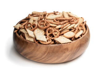 Crunchy mix of pretzels and crackers in wooden bowl isolated on white