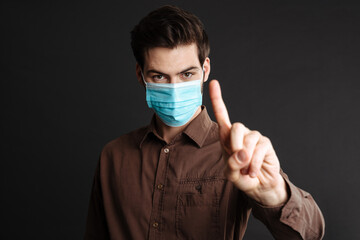 Close up of a confident young man in medical protective mask