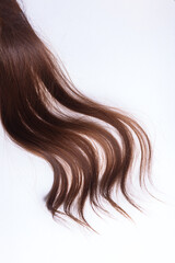 Naklejka premium a lock of natural brunette hair on a white background