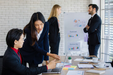 A group of diverse businesspeople, Asian and caucasian, working together in a modern office in an intimate manner. Idea for teamwork and good business colleagues