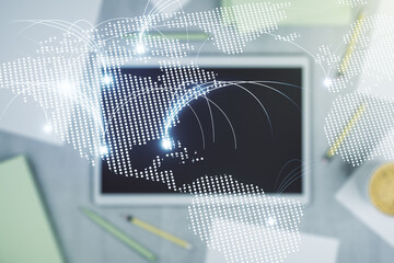 Double exposure of abstract digital world map with connections and digital tablet on background, top view, research and strategy concept