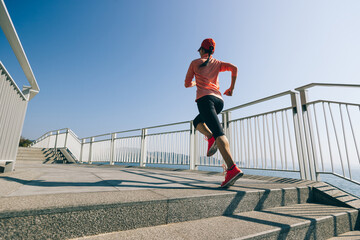Healthy lifestyle fitness sports woman runner running on seaside trail