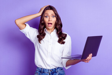 Photo of troubled lady hold computer hand head open mouth wear white shirt isolated violet color background - Powered by Adobe