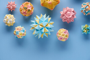 Set of multicolor handmade modular origami balls or Kusudama Isolated on blue background. Visual...