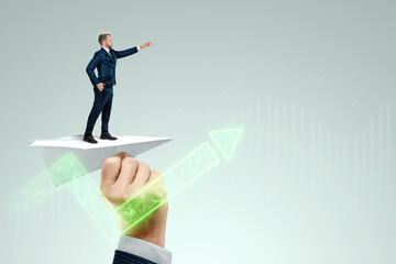 Startup. Businessman flying on a paper airplane with the pushing hand of an investor. Concept for opportunities, investments, business trends, business angels.