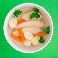 broth with chicken and egg on a white plate on a green background. close-up. photo for clipping. for the menu
