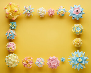 Set of multicolor handmade modular origami balls or Kusudama Isolated on yellow background. Visual...