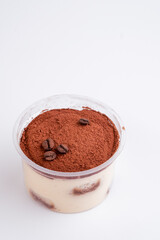 Traditional Italian dessert Tiramisu in plastic container on white background. Food delivery concept. Photo for clipping, for the menu