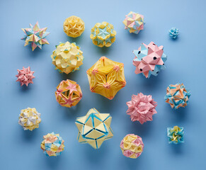 Set of multicolor handmade modular origami balls or Kusudama Isolated on blue background. Visual...