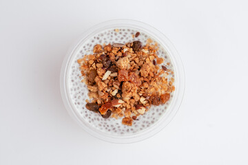 Chia pudding with mango in plastic container on green background. Top view. Close up. Photo for clipping, for the menu