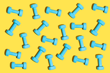 Fitness pattern in baby blue and trendy yellow. Fitness dumbbell concept on the minimal background.