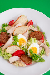 Caesar salad on a white plate close-up. 