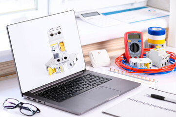 . Electrical installation courses. On the table there is a computer, cable, tester, automatic switch. Online learning