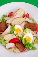 Caesar salad on a white plate close-up. 