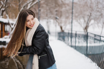 Happy girl smiling and looking aside while walking in winter park