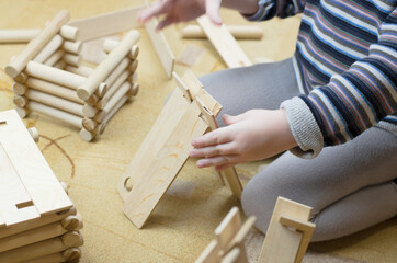 Child plays with a wooden construction set